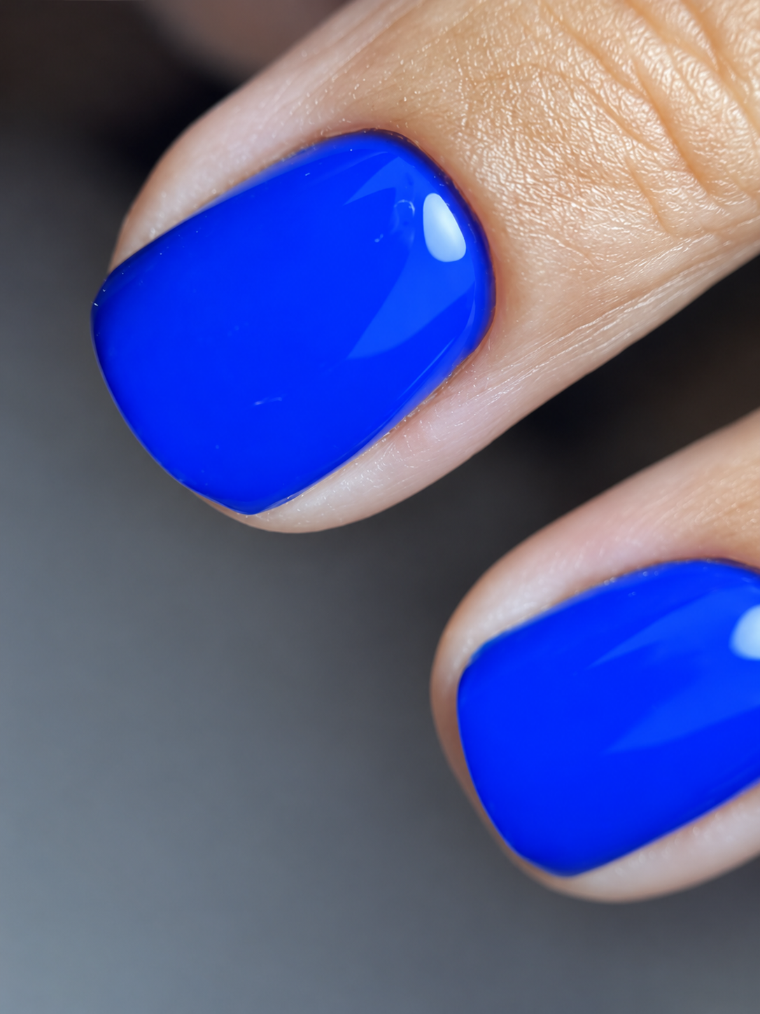 Uñas azules en primer plano, cutícula y aplicación prolijas